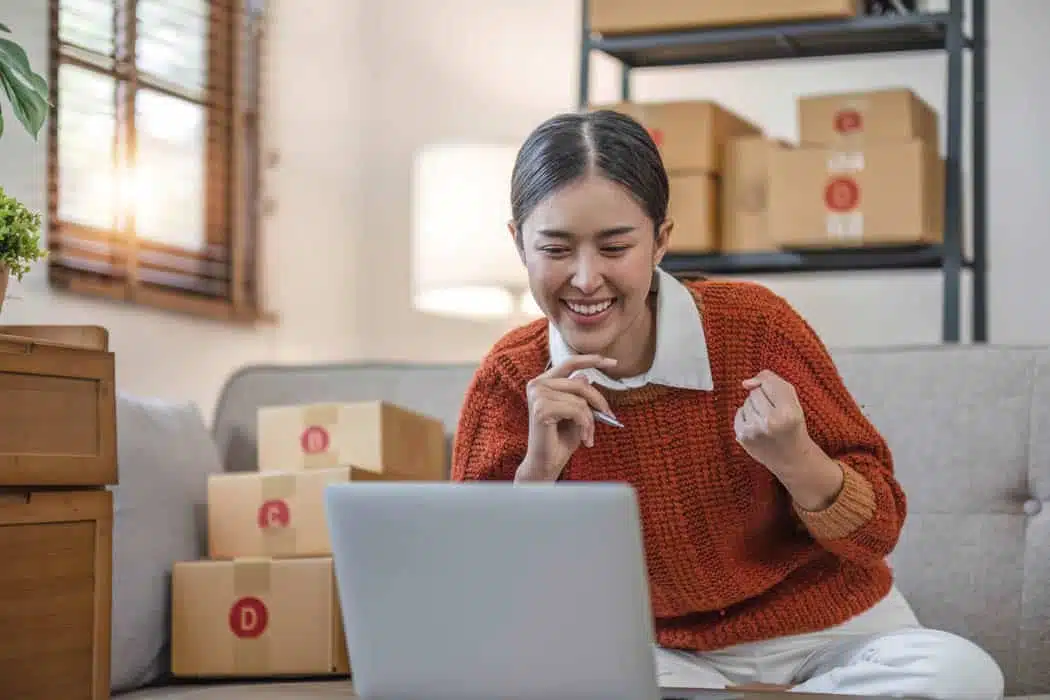Asian business woman leaning on the sofa use laptop computer checking customer order online shipping boxes at home. Starting Small business entrepreneur SME. Online business, Work at home concept. Asian business woman leaning on the sofa use laptop computer checking customer order online shipping boxes at home. Starting Small business entrepreneur SME. Online business, Work at home concept...